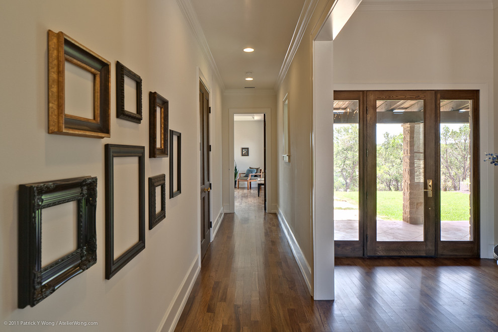 Transitional hallway in Austin with white walls.