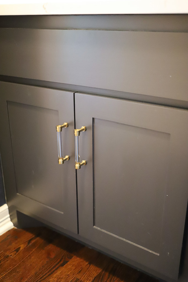 Example of a small transitional 3/4 medium tone wood floor and brown floor bathroom design with shaker cabinets, gray cabinets, a one-piece toilet, blue walls, an undermount sink, quartz countertops and white countertops