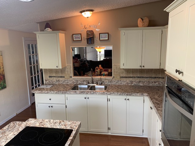 Eat-in kitchen - large l-shaped eat-in kitchen idea with shaker cabinets, beige cabinets, laminate countertops, an island and brown countertops