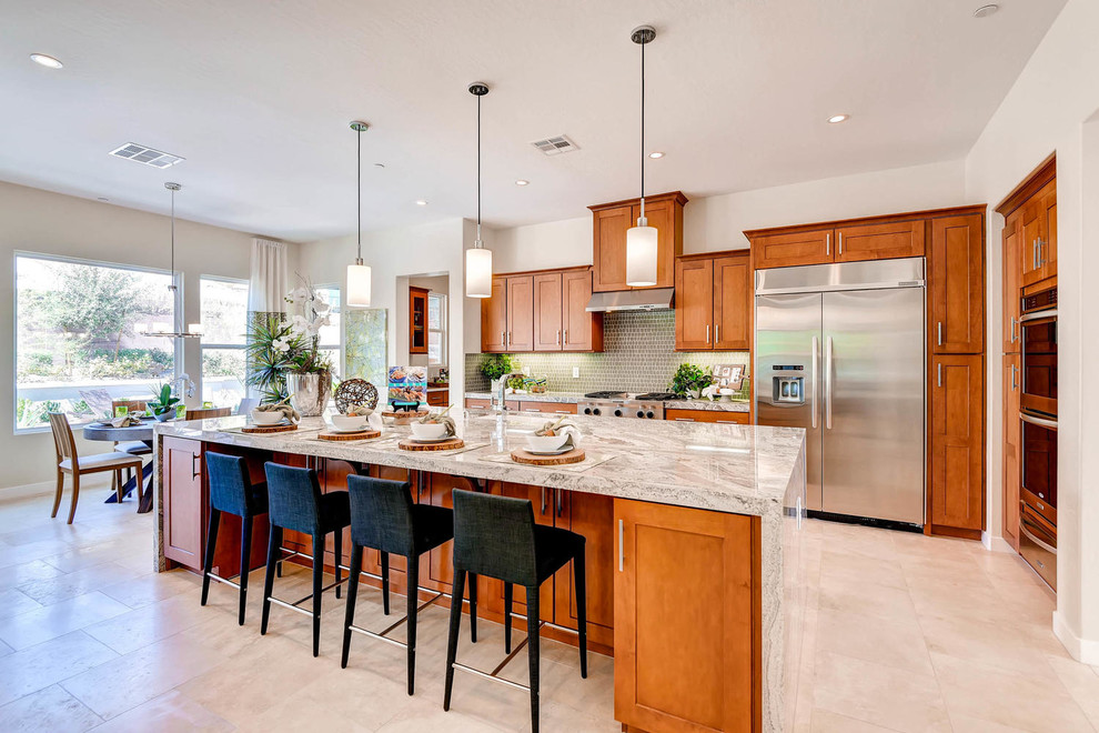 Design ideas for a large transitional galley open plan kitchen in Las Vegas with an undermount sink, shaker cabinets, medium wood cabinets, granite benchtops, green splashback, ceramic splashback, stainless steel appliances, ceramic floors and with island.