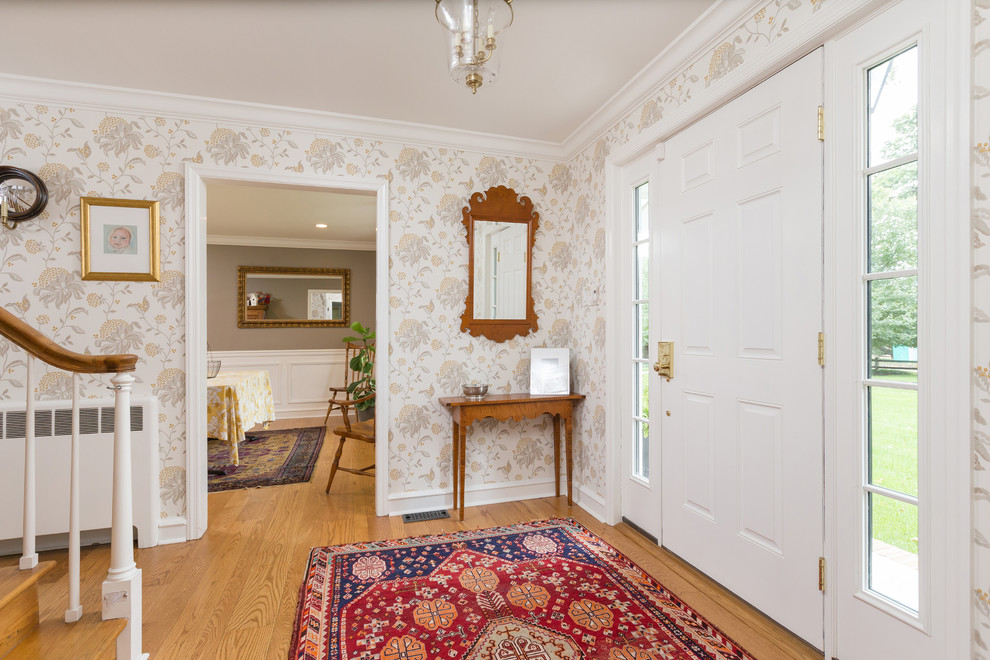 Photo of a country foyer in Philadelphia with multi-coloured walls, a single front door, a white front door, brown floor and medium hardwood floors.