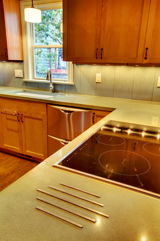 Mid-sized transitional u-shaped dark wood floor eat-in kitchen photo in Seattle with an undermount sink, shaker cabinets, medium tone wood cabinets, concrete countertops, green backsplash, ceramic backsplash, stainless steel appliances, gray walls and a peninsula