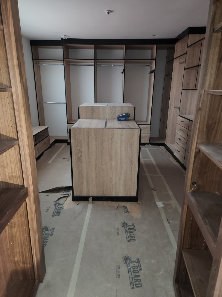 Large walk-in wardrobe in Los Angeles with flat-panel cabinets, light wood cabinets and medium hardwood floors.