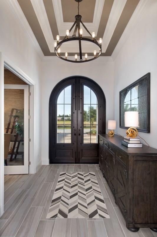 Photo of a small transitional foyer in Miami with white walls, porcelain floors, a double front door, a dark wood front door and grey floor.