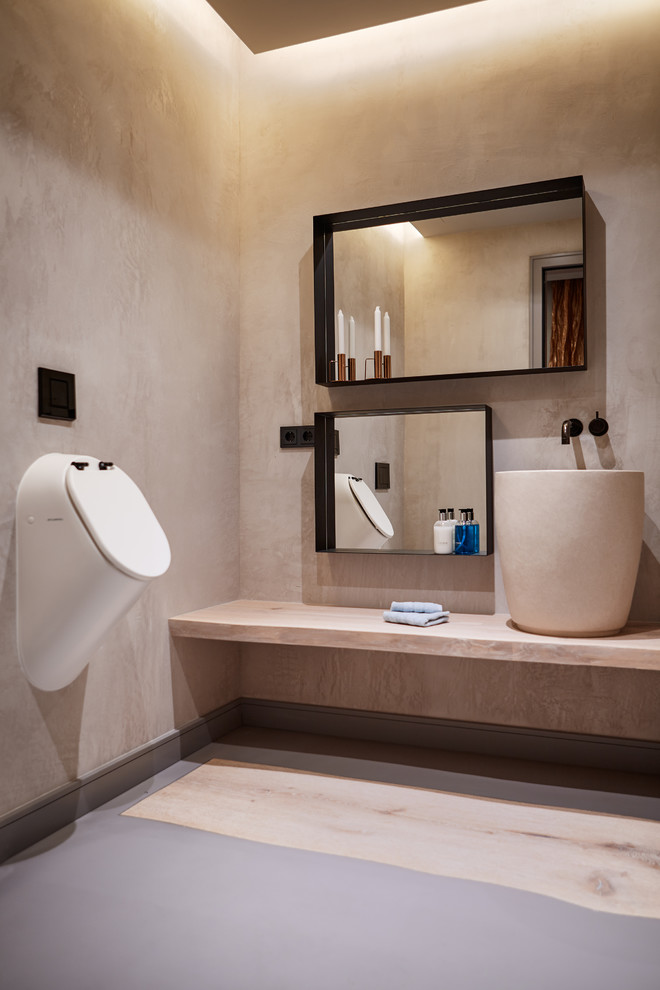 Inspiration for a mid-sized contemporary bathroom in Palma de Mallorca with an urinal, beige walls, a vessel sink, grey floor and beige benchtops.