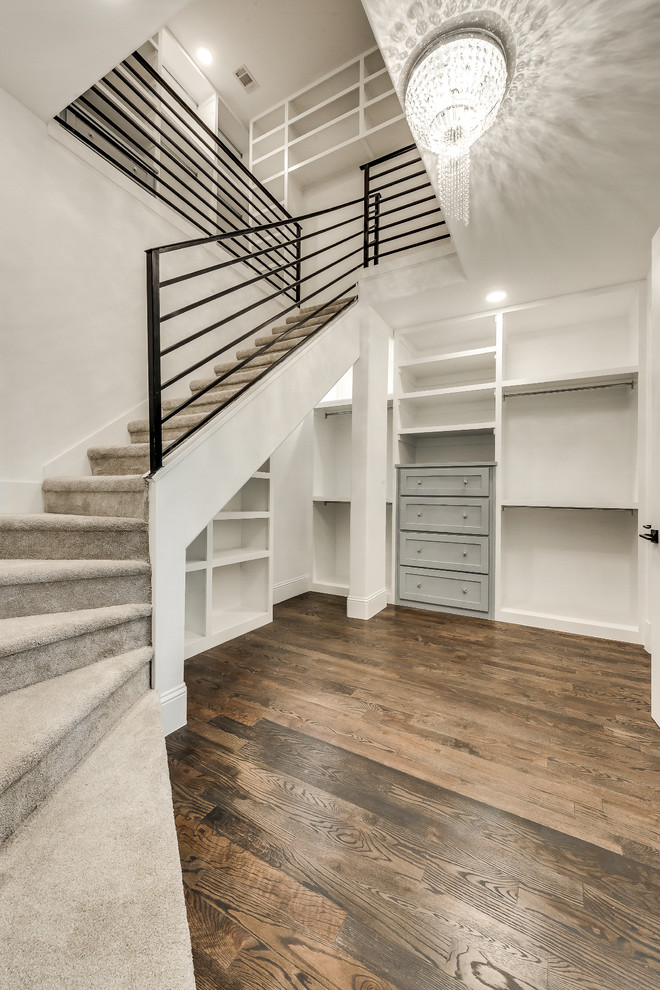Large transitional gender-neutral walk-in wardrobe in Dallas with recessed-panel cabinets, grey cabinets, medium hardwood floors and brown floor.