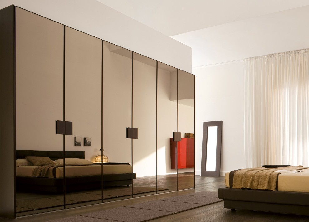Inspiration for a large contemporary gender-neutral built-in wardrobe in Dallas with dark hardwood floors and brown floor.