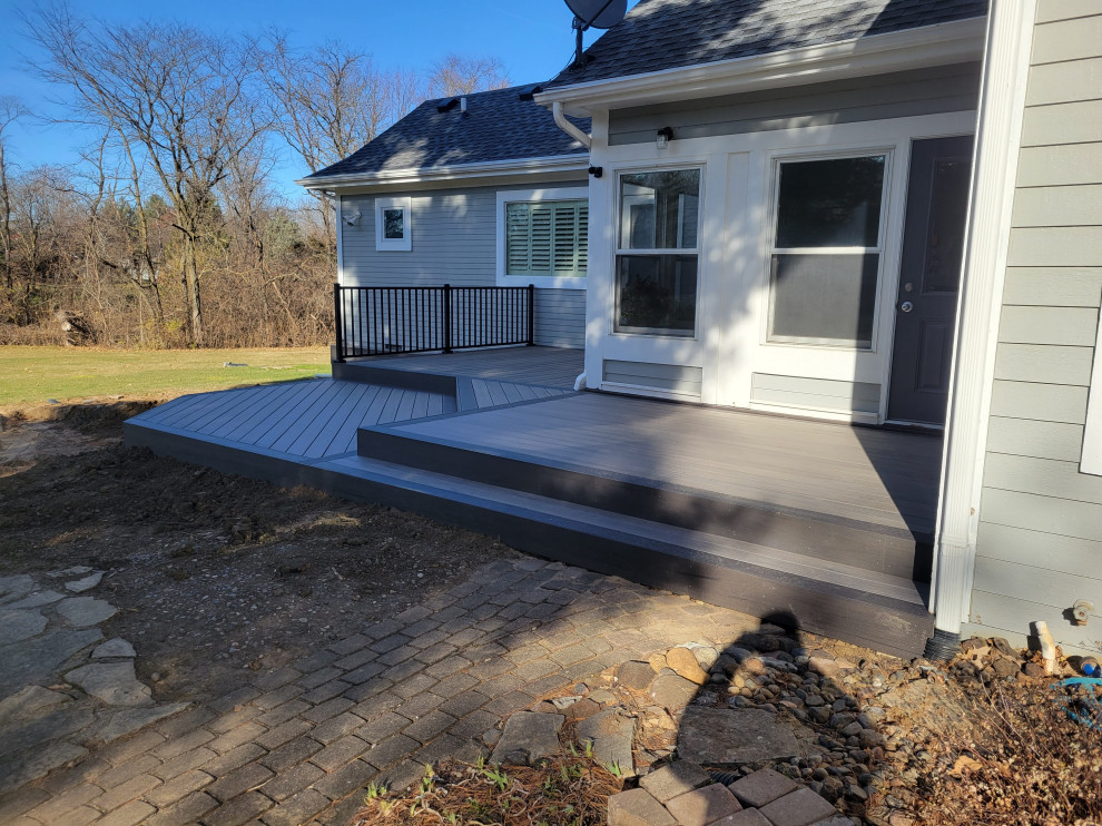 Deck - mid-sized backyard ground level metal railing deck idea with no cover