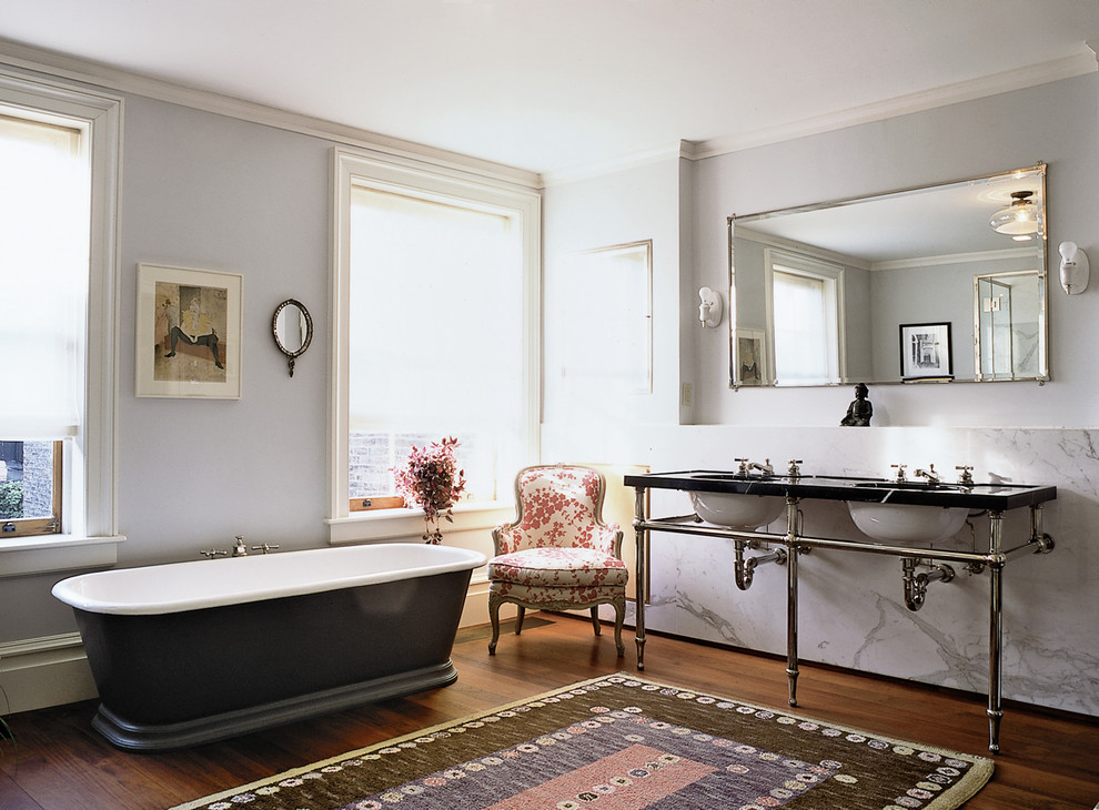 Large traditional master bathroom in New York with a freestanding tub, dark hardwood floors and a console sink.