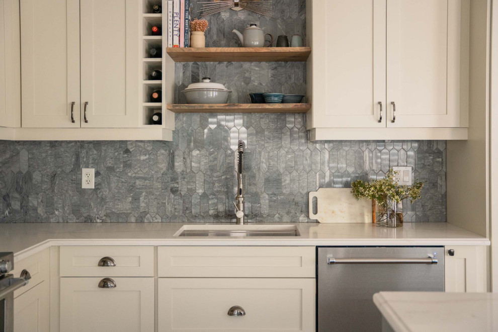 Example of a mid-sized transitional l-shaped dark wood floor and brown floor eat-in kitchen design in Toronto with an undermount sink, shaker cabinets, white cabinets, quartz countertops, gray backsplash, marble backsplash, stainless steel appliances, an island and multicolored countertops