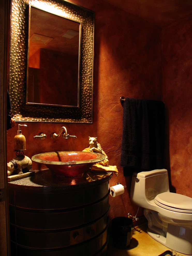 Photo of a mid-sized midcentury powder room in Milwaukee with a vessel sink, furniture-like cabinets, dark wood cabinets, marble benchtops and red walls.