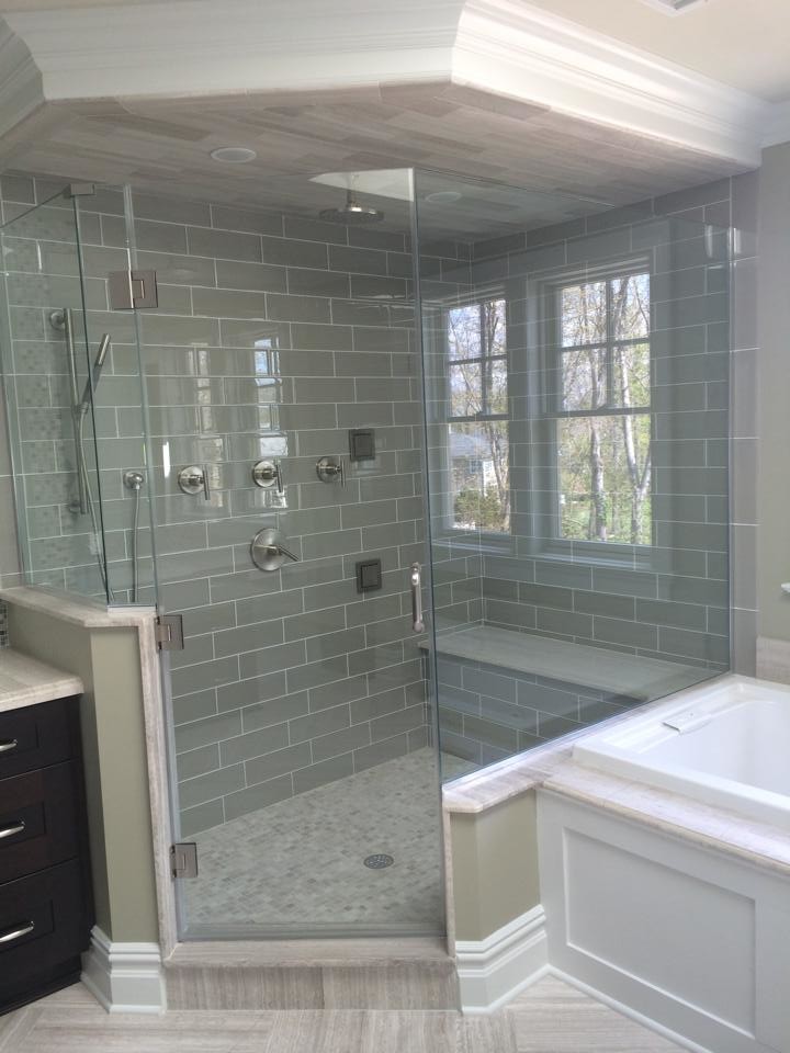 This is an example of a mid-sized traditional master bathroom in New York with a drop-in tub, a corner shower, gray tile, subway tile, brown walls and porcelain floors.