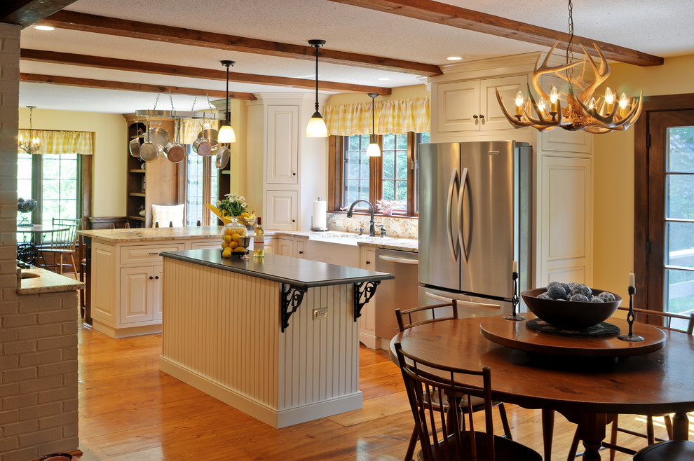 Example of a mid-sized transitional u-shaped medium tone wood floor and brown floor eat-in kitchen design in Boston with white cabinets, granite countertops, stainless steel appliances, an island, a farmhouse sink and raised-panel cabinets