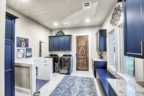 Mud room with blue cabinets and a dog shower. 