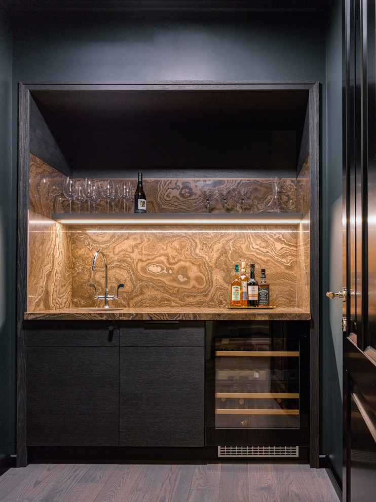 This is an example of a small contemporary single-wall wet bar in Moscow with flat-panel cabinets, marble benchtops, marble splashback and dark hardwood floors.