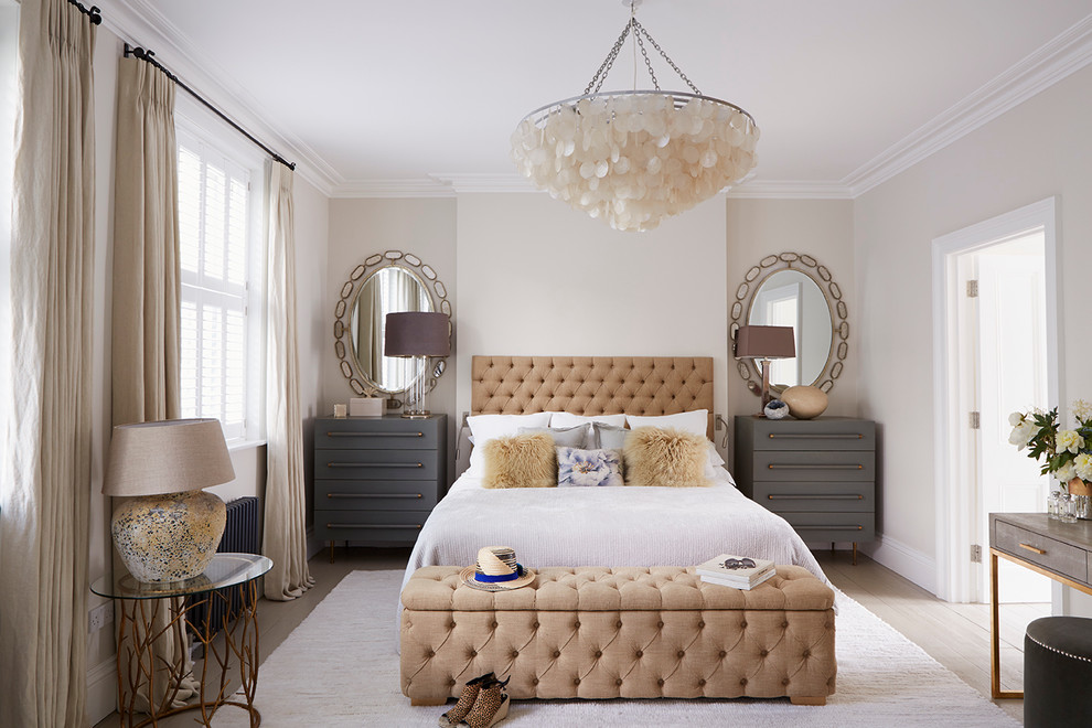 Transitional master bedroom in London with beige walls and light hardwood floors.