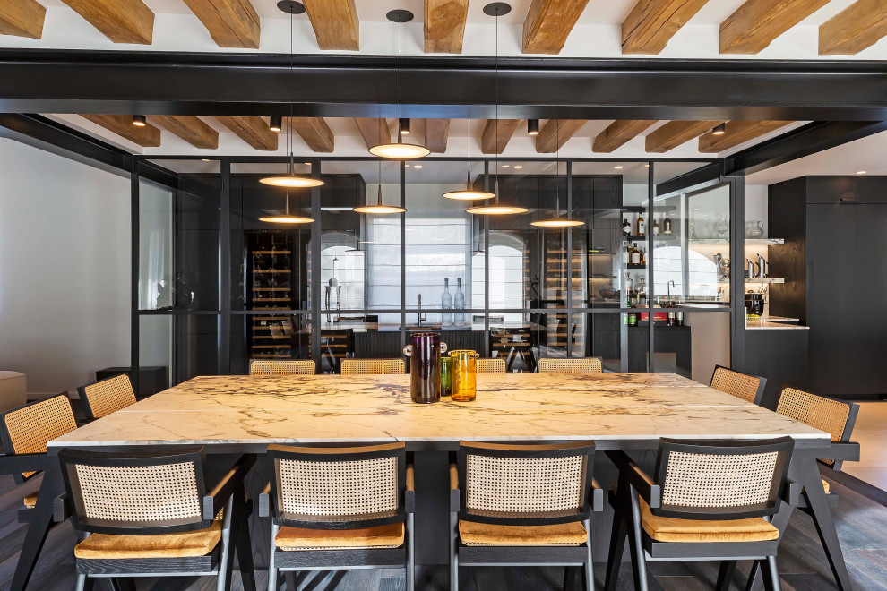 Immagine di una grande sala da pranzo aperta verso il soggiorno industriale con pareti beige, parquet scuro e pavimento nero