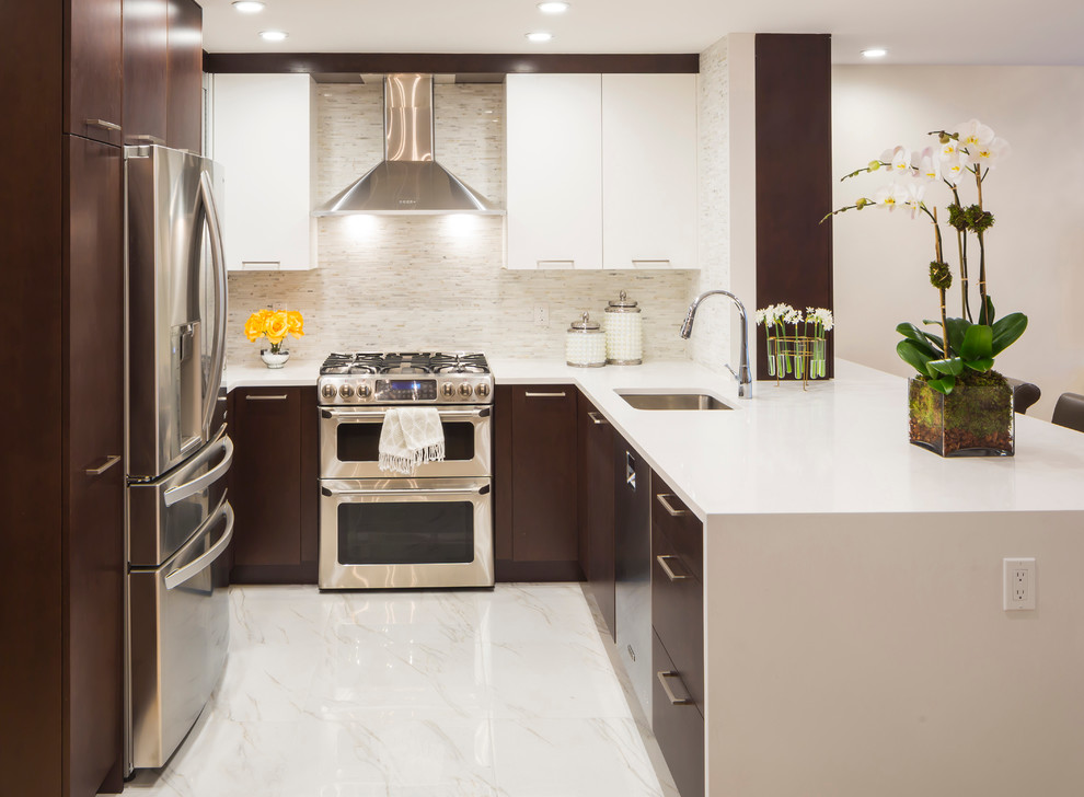 This is an example of a mid-sized transitional u-shaped eat-in kitchen in New York with flat-panel cabinets, quartz benchtops, white splashback, mosaic tile splashback, stainless steel appliances, an undermount sink, white cabinets, marble floors and a peninsula.