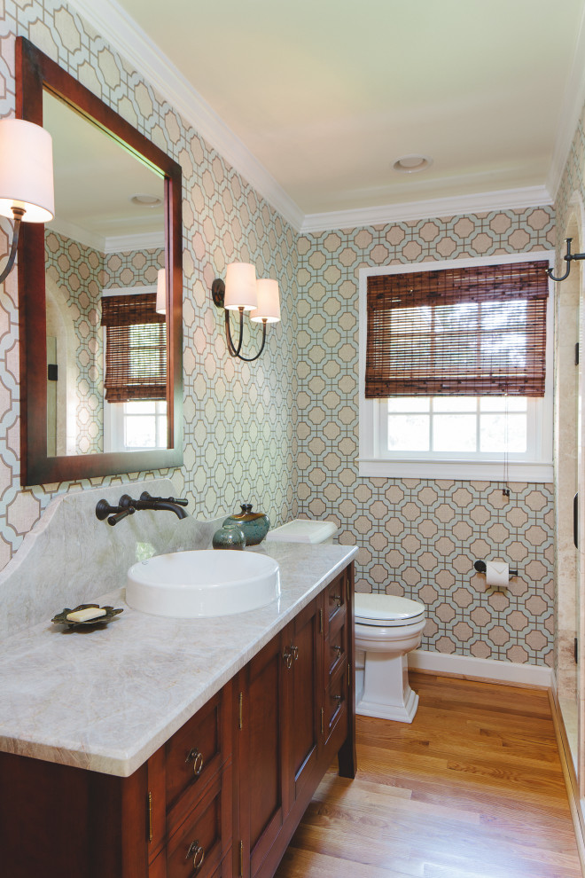 Photo of a mid-sized traditional 3/4 bathroom in Atlanta with medium wood cabinets, an alcove shower, a two-piece toilet, multi-coloured tile, stone tile, beige walls, a vessel sink, quartzite benchtops, a hinged shower door, beige benchtops, a niche, a single vanity, a freestanding vanity and shaker cabinets.