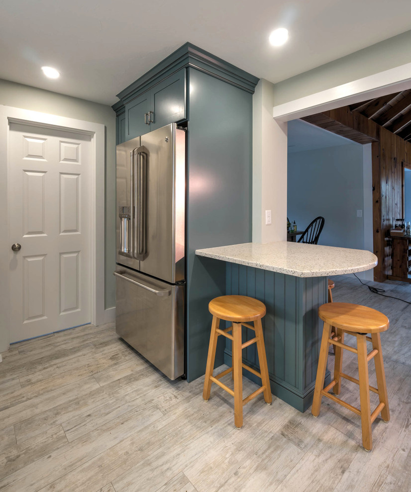 Photo of a small modern l-shaped kitchen pantry in Boston with a farmhouse sink, shaker cabinets, blue cabinets, recycled glass benchtops, white splashback, ceramic splashback, stainless steel appliances, ceramic floors, with island and beige floor.