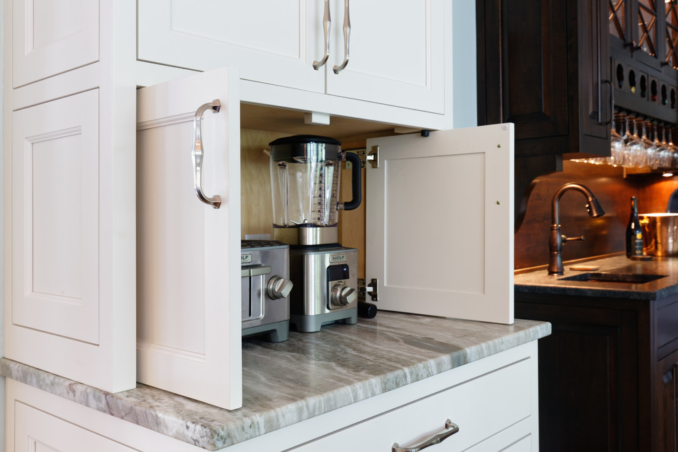 Transitional medium tone wood floor eat-in kitchen photo in Cincinnati with an undermount sink, recessed-panel cabinets, white cabinets, quartzite countertops, white backsplash and paneled appliances