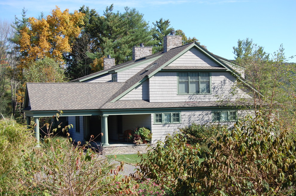 Large traditional split-level grey exterior in Boston with concrete fiberboard siding and a clipped gable roof.