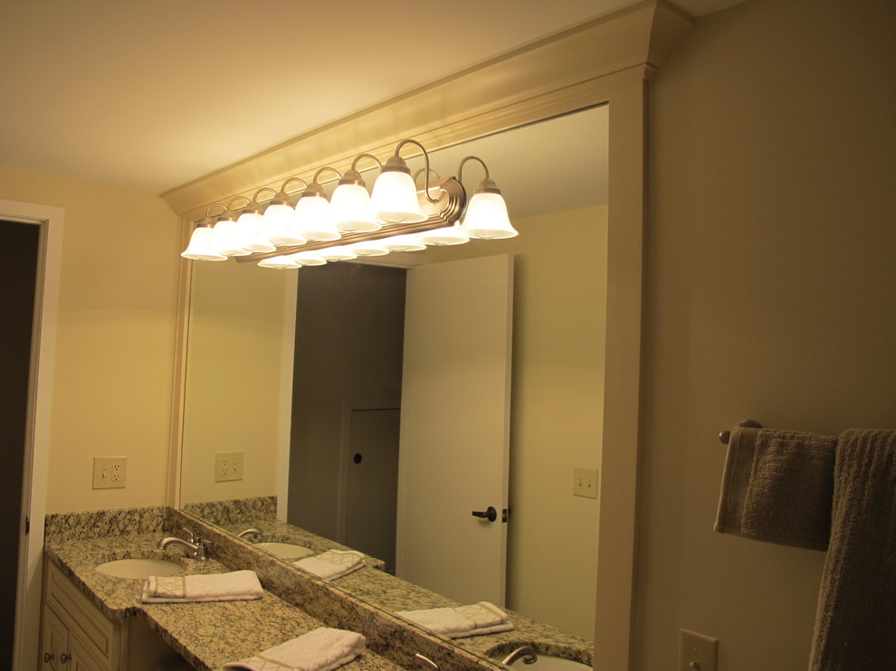 Mid-sized transitional beige tile and stone tile porcelain tile alcove bathtub photo with an undermount sink, raised-panel cabinets, white cabinets, marble countertops and beige walls