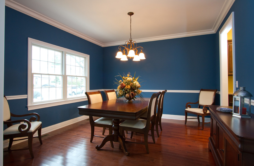 Photo of a mid-sized transitional separate dining room in New York with blue walls, dark hardwood floors, no fireplace and brown floor.