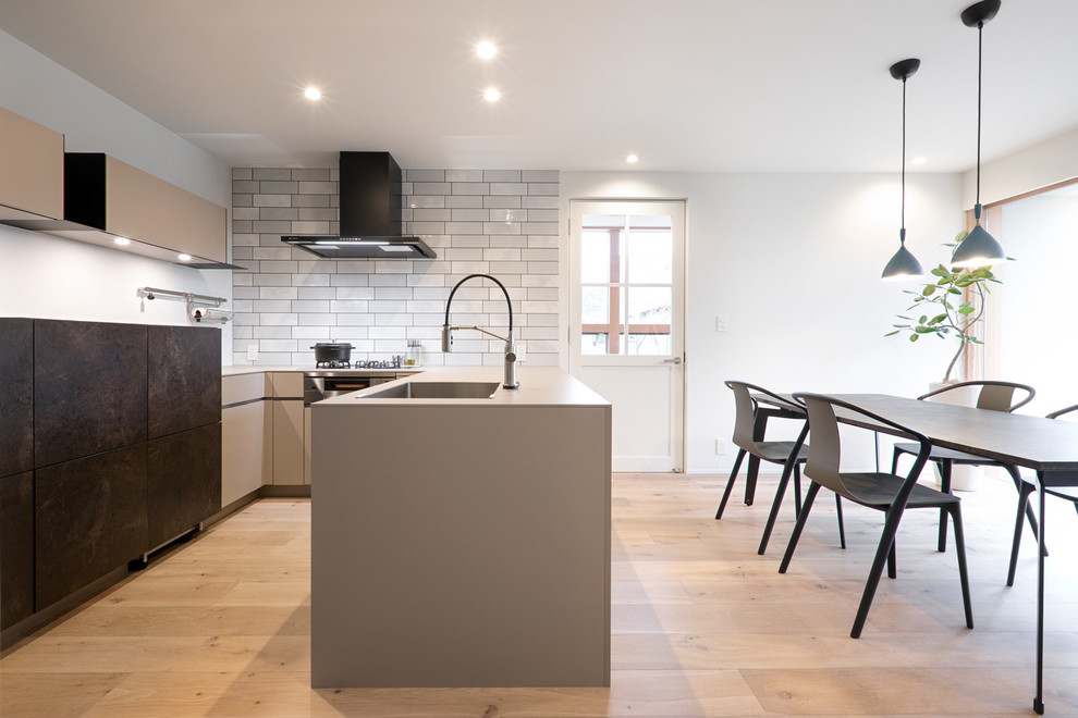 Modern u-shaped eat-in kitchen with an undermount sink, beaded inset cabinets, grey cabinets, grey splashback, stainless steel appliances, light hardwood floors, no island and beige floor.