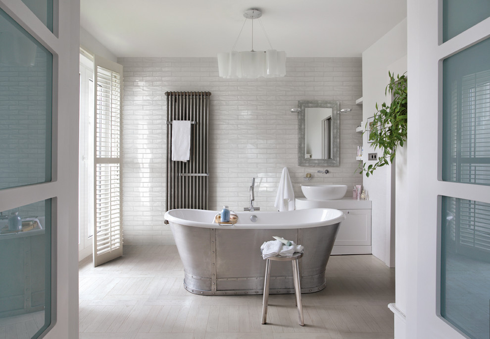 Large transitional master bathroom in Other with a vessel sink, shaker cabinets, white cabinets, a freestanding tub, white tile, subway tile, white walls and light hardwood floors.