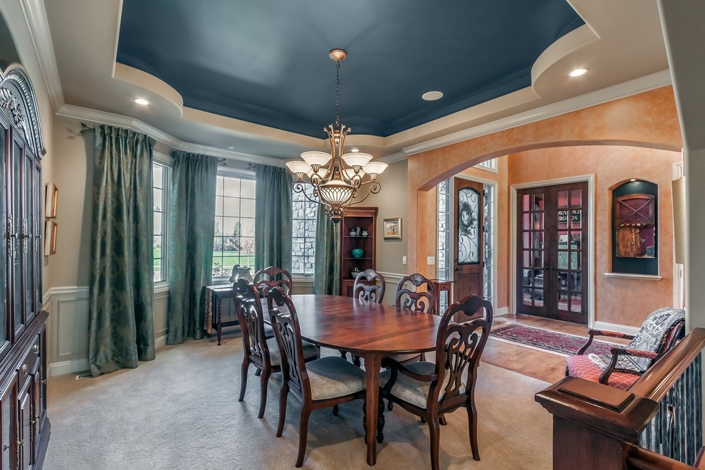Dining room - huge transitional medium tone wood floor dining room idea in Omaha with orange walls and a medium wood front door