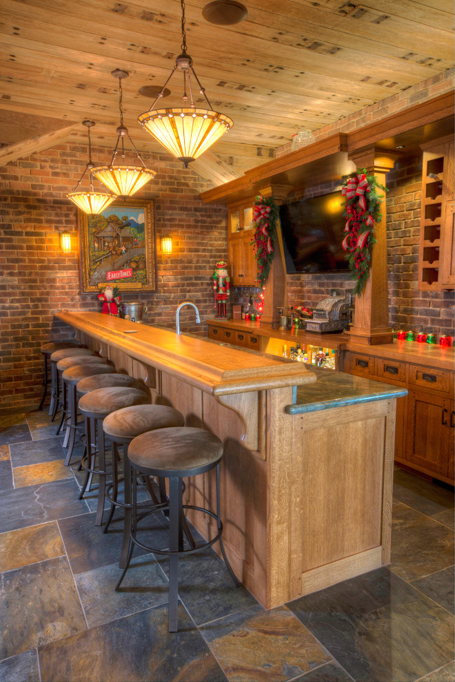 This is an example of a mid-sized arts and crafts galley seated home bar in San Luis Obispo with shaker cabinets, light wood cabinets, granite benchtops, multi-coloured splashback, brick splashback and limestone floors.