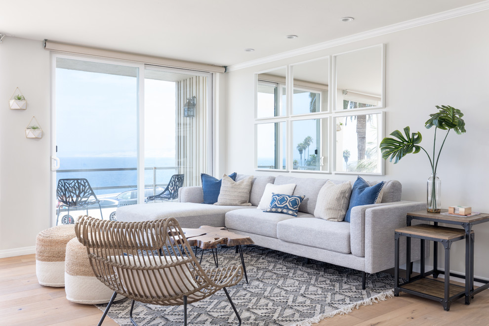 Photo of a beach style open concept living room in San Diego with grey walls, light hardwood floors and no fireplace.
