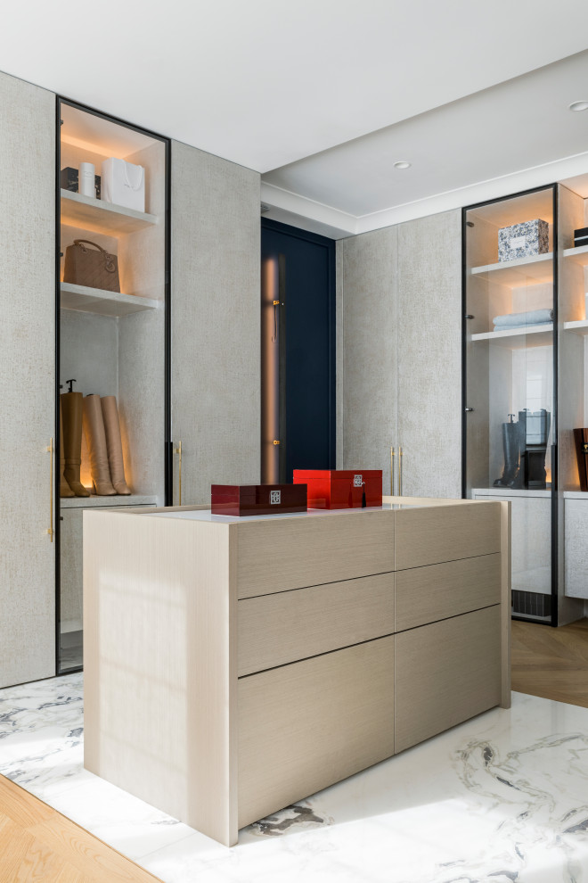 Design ideas for a large contemporary gender neutral dressing room in Paris with beaded cabinets, grey cabinets, light hardwood flooring and beige floors.