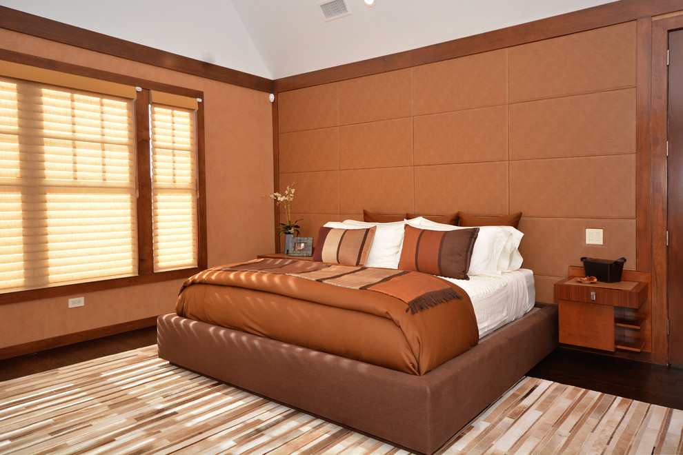 Mid-sized contemporary master bedroom in New York with orange walls, dark hardwood floors, a two-sided fireplace, a stone fireplace surround and brown floor.