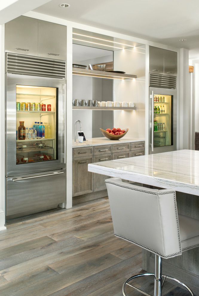 Inspiration for a large country galley kitchen pantry in Denver with an undermount sink, recessed-panel cabinets, grey cabinets, quartzite benchtops, white splashback, stone slab splashback, stainless steel appliances, medium hardwood floors, with island, grey floor and white benchtop.