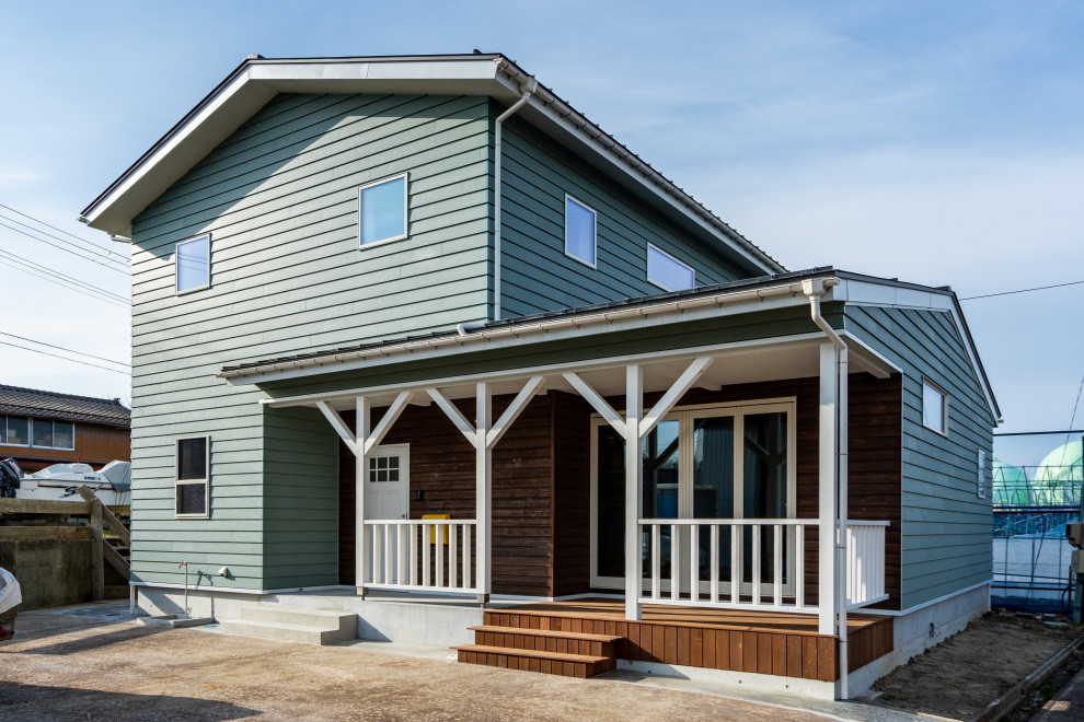 Inspiration pour une façade de maison verte sud-ouest américain à un étage avec un revêtement mixte, un toit à deux pans, un toit en métal et un toit gris.