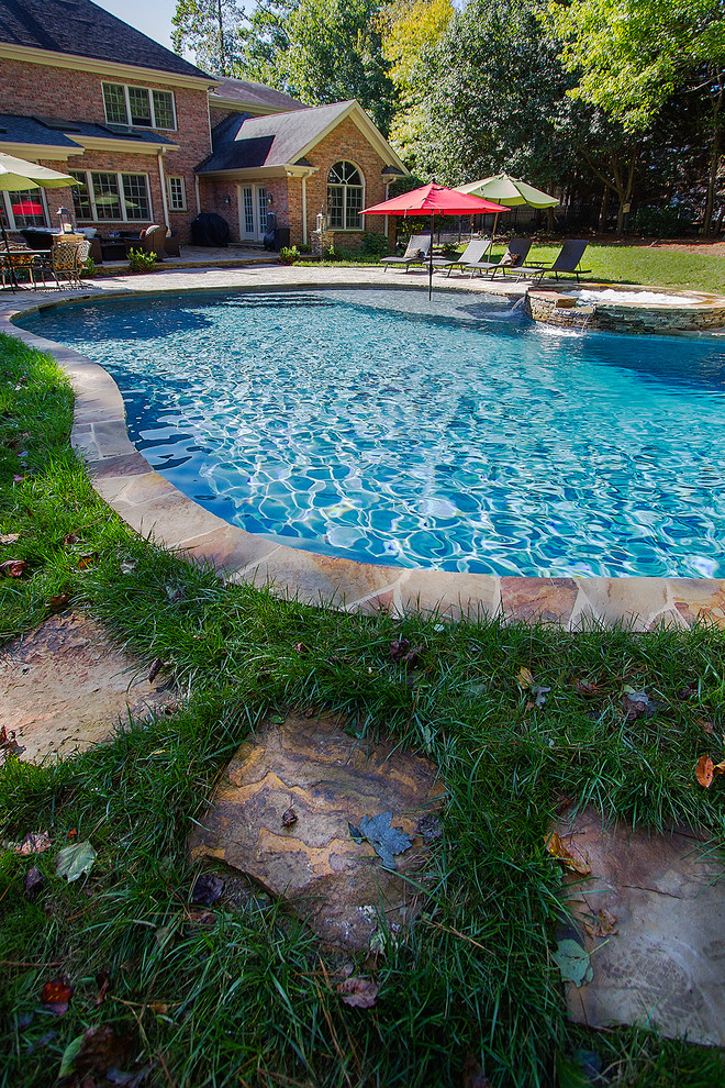 Example of a large mountain style backyard concrete paver and custom-shaped natural hot tub design in Raleigh