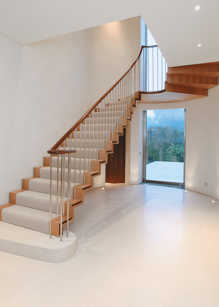 Photo of a contemporary wood u-shaped staircase in London with wood risers.