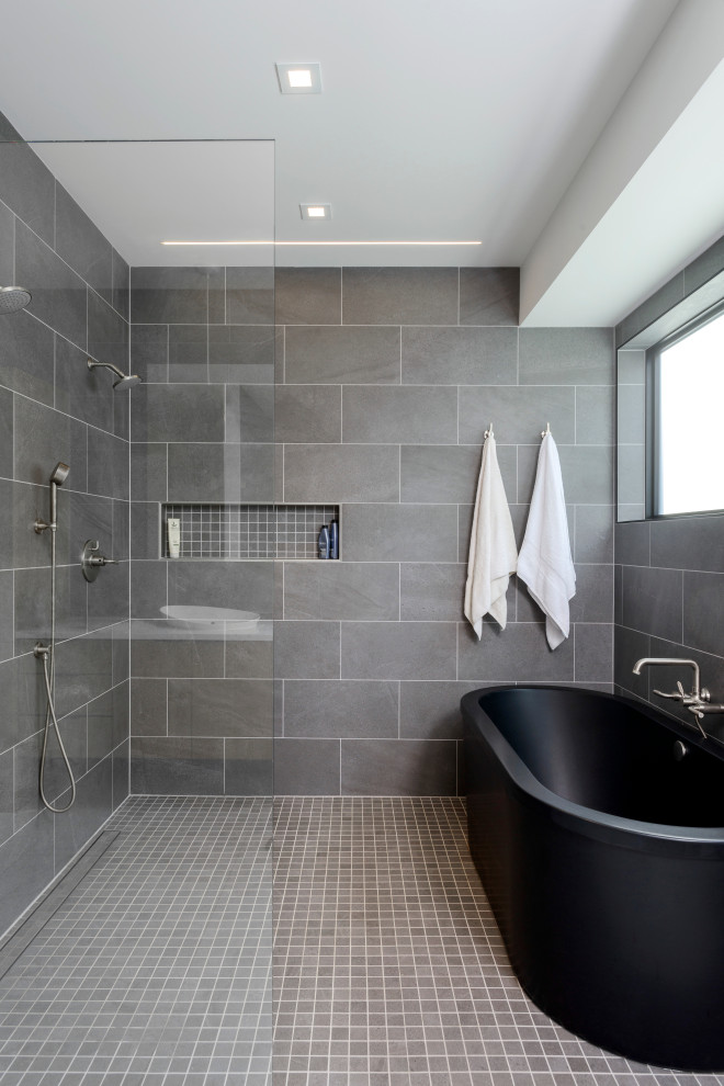 This is an example of a mid-sized contemporary bathroom in Seattle with a freestanding tub, a curbless shower, gray tile, white walls, mosaic tile floors, grey floor and an open shower.