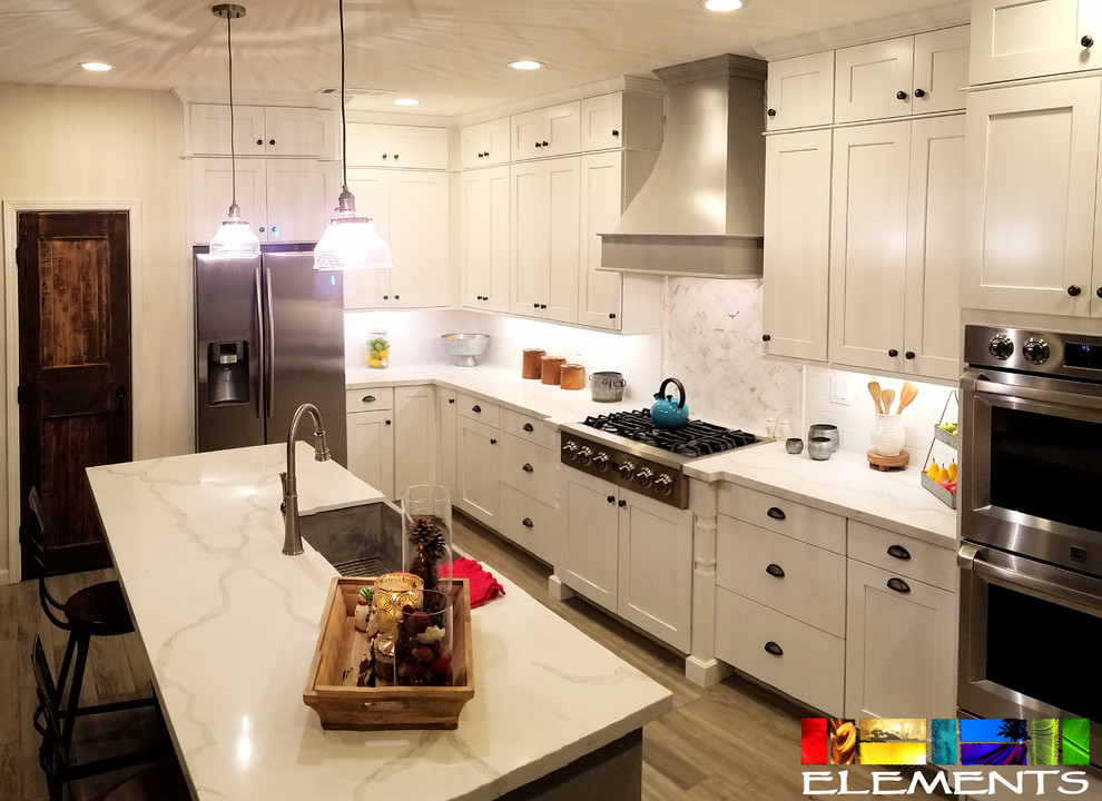 Example of a large transitional porcelain tile and beige floor eat-in kitchen design with a farmhouse sink, shaker cabinets, white cabinets, quartzite countertops, white backsplash, subway tile backsplash, stainless steel appliances and an island