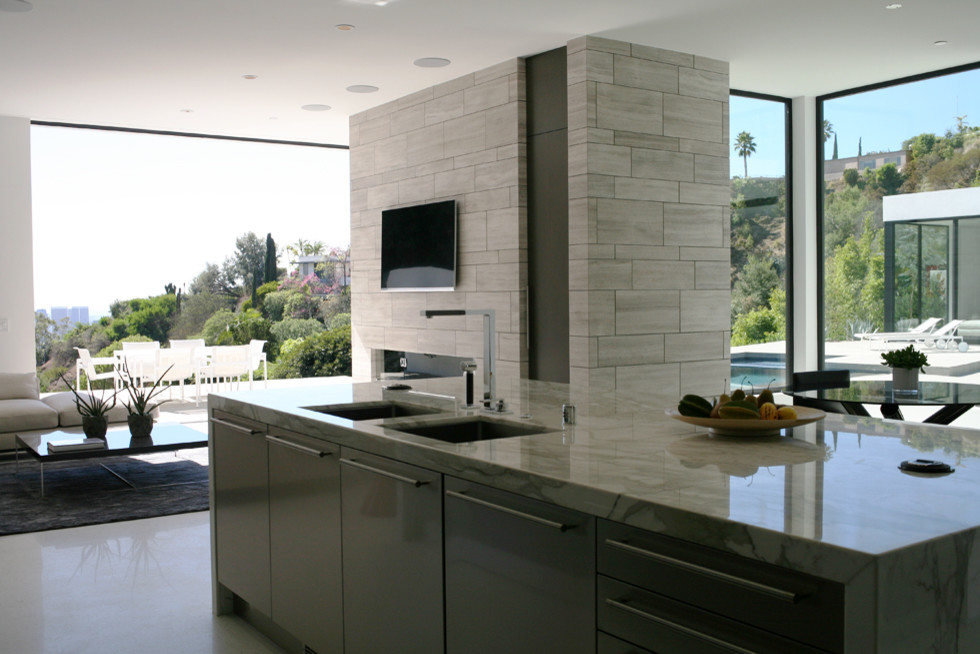 Design ideas for a mid-sized modern l-shaped open plan kitchen in Los Angeles with an undermount sink, flat-panel cabinets, dark wood cabinets, marble benchtops, white splashback, stone slab splashback, stainless steel appliances, concrete floors, with island, white floor and white benchtop.