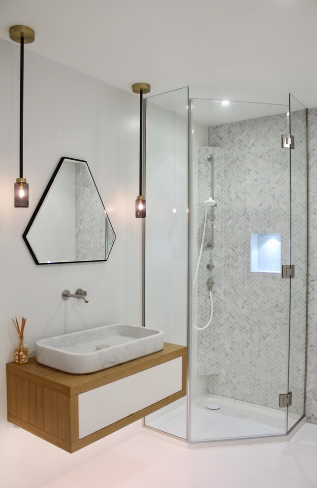 This is an example of a mid-sized contemporary bathroom in London with flat-panel cabinets, white cabinets, a corner shower, ceramic tile, grey walls, a wall-mount sink and white floor.