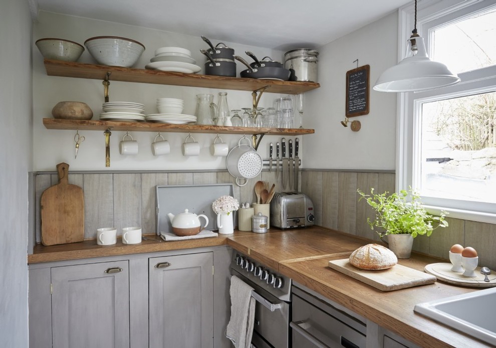 Small country l-shaped eat-in kitchen in Cornwall with an undermount sink, shaker cabinets, grey cabinets, wood benchtops, grey splashback, timber splashback, stainless steel appliances, painted wood floors and white floor.
