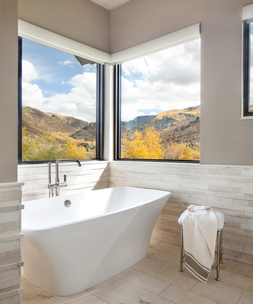 This is an example of a large transitional master bathroom in Denver with a freestanding tub, beige walls, flat-panel cabinets, white cabinets, an alcove shower, white tile, ceramic tile, ceramic floors, an undermount sink, white floor and a hinged shower door.