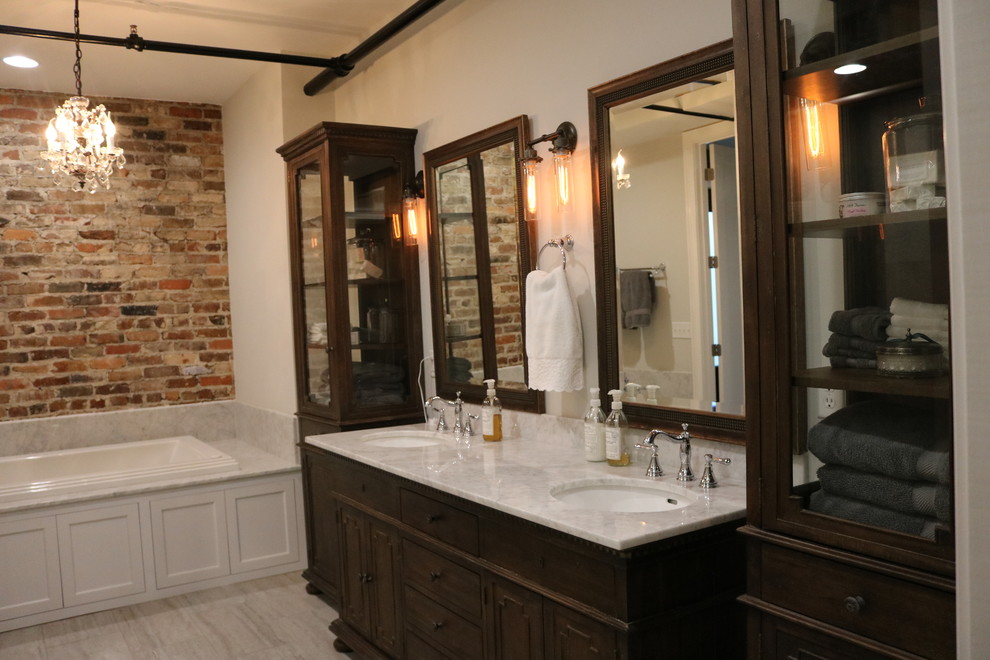 Mid-sized industrial 3/4 bathroom in Other with white walls, laminate floors, furniture-like cabinets, dark wood cabinets, a drop-in tub, marble benchtops and an undermount sink.