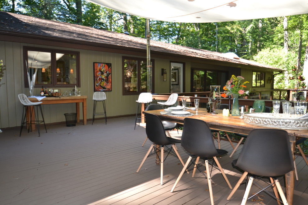 This is an example of a large eclectic backyard deck in Wilmington with an awning.