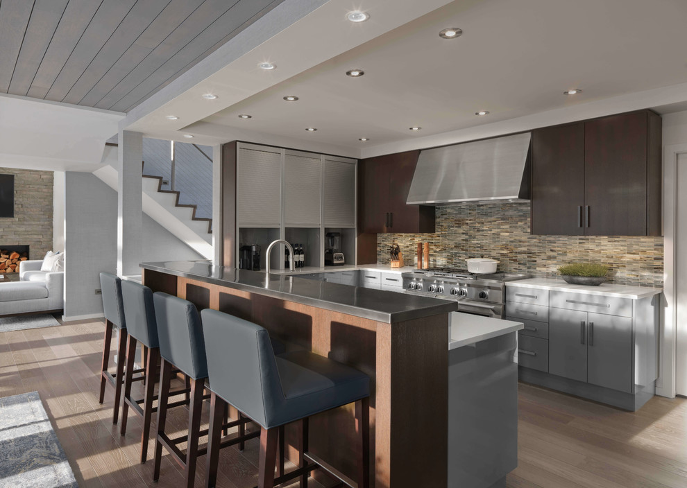 Design ideas for a mid-sized contemporary u-shaped eat-in kitchen in Burlington with flat-panel cabinets, dark wood cabinets, stainless steel appliances, light hardwood floors, beige floor, marble benchtops, beige splashback, glass tile splashback and a peninsula.