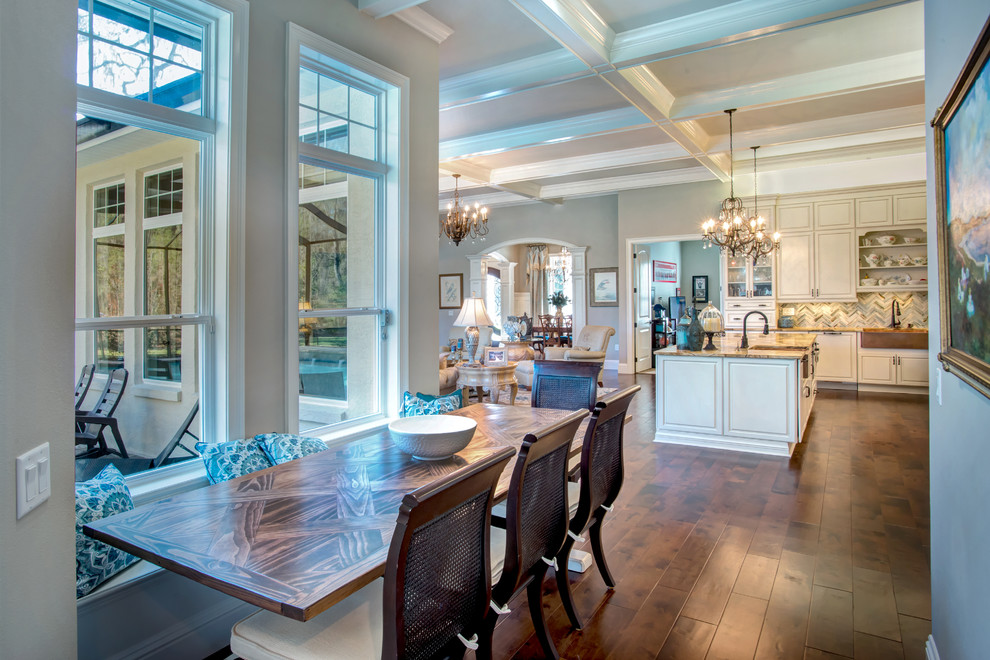 Inspiration for a large transitional l-shaped dark wood floor and brown floor open concept kitchen remodel in Orlando with a farmhouse sink, raised-panel cabinets, white cabinets, granite countertops, blue backsplash, stone tile backsplash, paneled appliances and an island