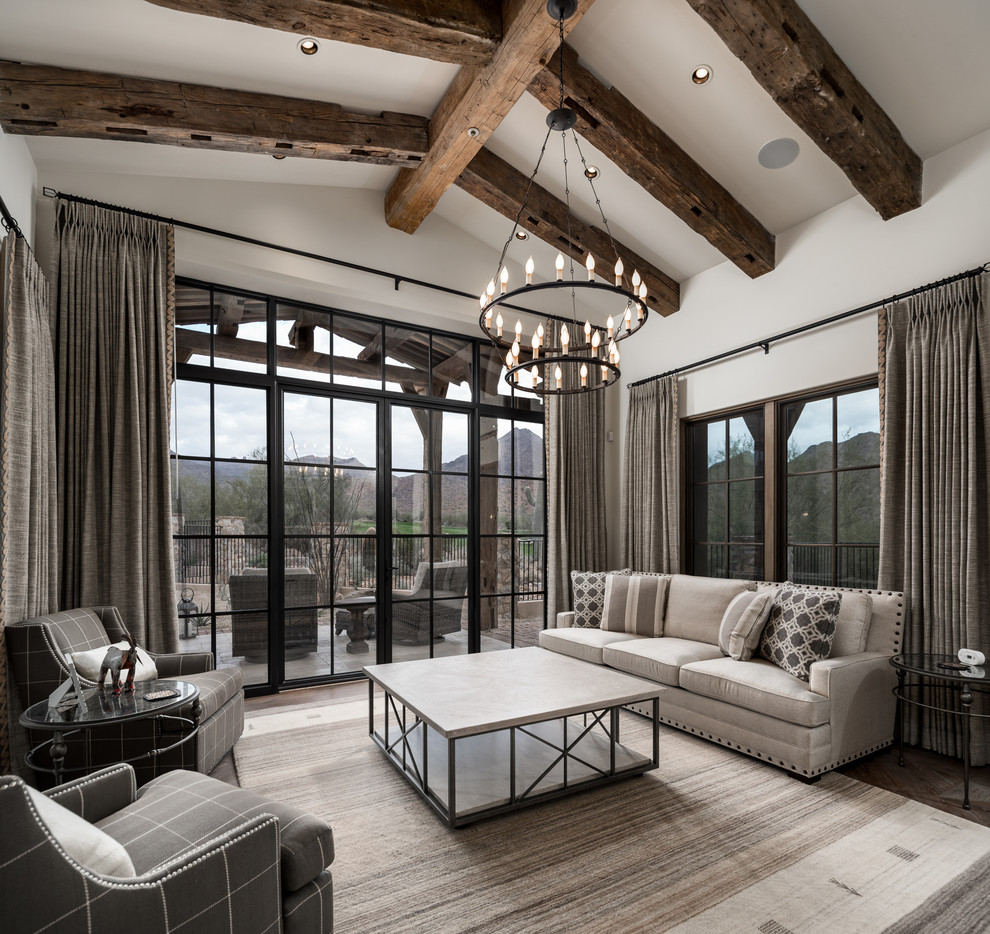 This is an example of an expansive country open concept living room in Phoenix with white walls, dark hardwood floors, a standard fireplace, a stone fireplace surround, a wall-mounted tv and brown floor.